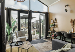 Bright living area in Rescue cottage at Duynpark Het Zwanenwater, Netherlands, with modern decor and patio view.