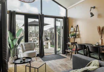 Sala luminosa en Rescue cottage en Duynpark Het Zwanenwater, Países Bajos, con decoración moderna y vista al patio.