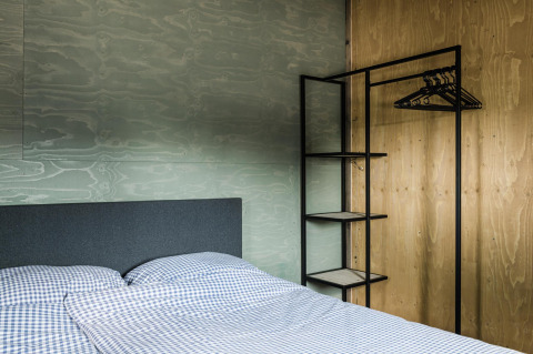 Chambre moderne au Rescue Cottage, Duynpark Het Zwanenwater, Pays-Bas, avec lit et armoire ouverte.