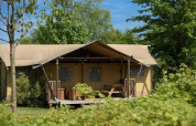 Tienda safari lodge de lujo con porche en medio de naturaleza en De Kleine Belties, Países Bajos.