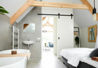 Tiny house Wellness Lodge moderne au Holiday Park De IJsvogel, Pays-Bas, avec poutres et salle de bain.