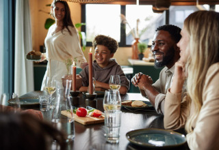 A family enjoys a meal together at Unbrick One | Sauna at Brinckerduyn lodge in the Netherlands.