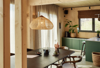 Eetruimte in Unbrick One | Sauna bij Brinckerduyn, Nederland, met houten meubilair en zonlicht.