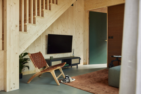 Sala moderna en Unbrick One | Sauna en Brinckerduyn, Países Bajos, con decoración de madera y televisor.
