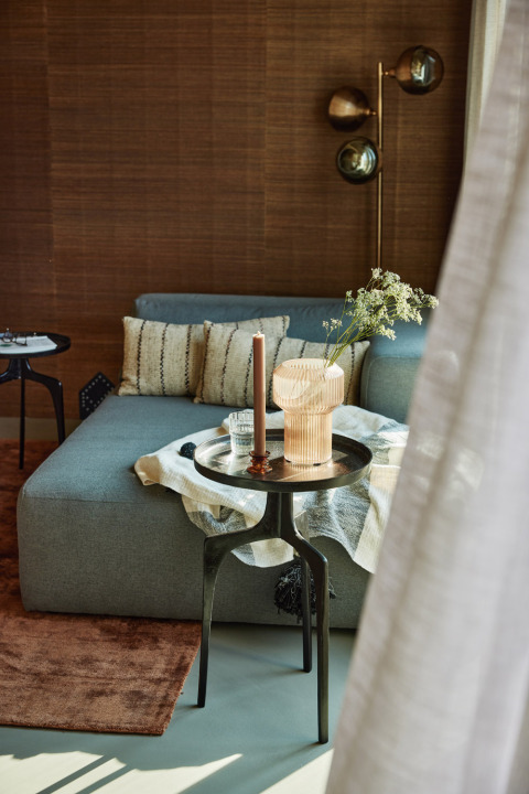 Sala contemporánea en Unbrick One | Sauna en Brinckerduyn, Países Bajos, con sofá y mesa decorativa.