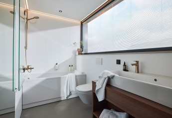 Modern, bright bathroom with large window, bathtub, sink and wooden details at Unbrick One | Sauna, Brinckerduyn.