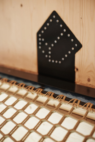 Close-up van hout en netvormig ontwerp in Unbrick One | Sauna bij Brinckerduyn, Nederland.