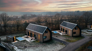 Modernas cabañas de madera con sauna y piscina al atardecer en Brinckerduyn, Unbrick One, Países Bajos.