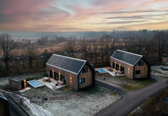 Modernas cabañas de madera con sauna y piscina al atardecer en Brinckerduyn, Unbrick One, Países Bajos.