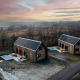 Modernas cabañas de madera con sauna y piscina al atardecer en Brinckerduyn, Unbrick One, Países Bajos.