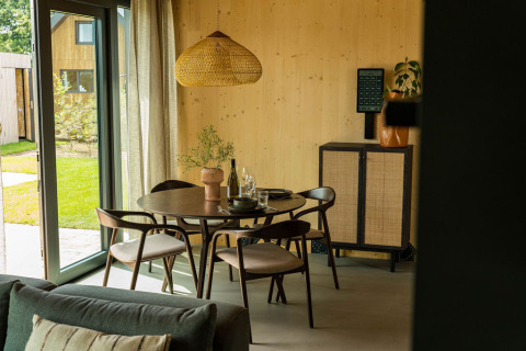 Comedor moderno en Unbrick One lodge en Brinckerduyn con muebles de madera y luz natural extensa.