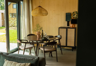 Zona pranzo moderna presso Unbrick One lodge a Brinckerduyn, con mobili in legno e ampie finestre.