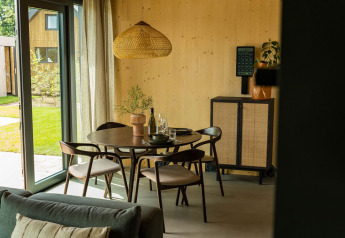 Moderne eethoek in Unbrick One lodge te Brinckerduyn met houten meubels en veel natuurlijk licht.