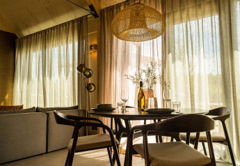 Sala da pranzo moderna con sedie in legno e luce soffusa presso Unbrick One Lodge nei Paesi Bassi.