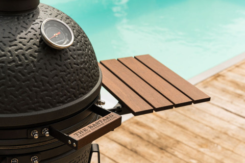 Parrilla cerámica negra con bandeja de madera junto a la piscina en Unbrick One | Sauna y Pool en Brinckerduyn, Países Bajos.