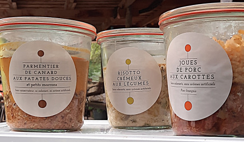 Tarros de vidrio con comida francesa en Eco domaine Le Camp, Occitanie, Francia. Etiquetas visibles.