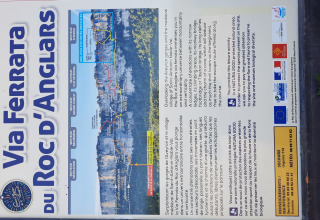 Informationsskilt for Via Ferrata du Roc d'Anglars nær Saint-Antonin-Noble-Val, med kort og instruktioner.