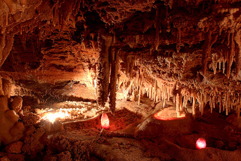 Grotte à stalactites près de Varen, Occitanie, France, éclairée par des lampes aux tons chauds et ambiance mystérieuse.