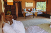 Interior de una tienda safari con cómodas camas en Tent Lodge Maasai Mara, Eco domaine Le Camp, Francia.