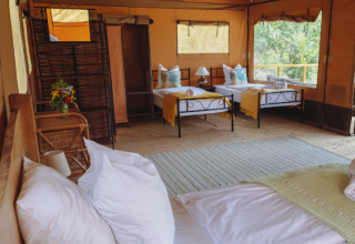 Innenansicht eines Safari-Zeltes mit gemütlichen Betten im Tent Lodge Maasai Mara, Eco domaine Le Camp.