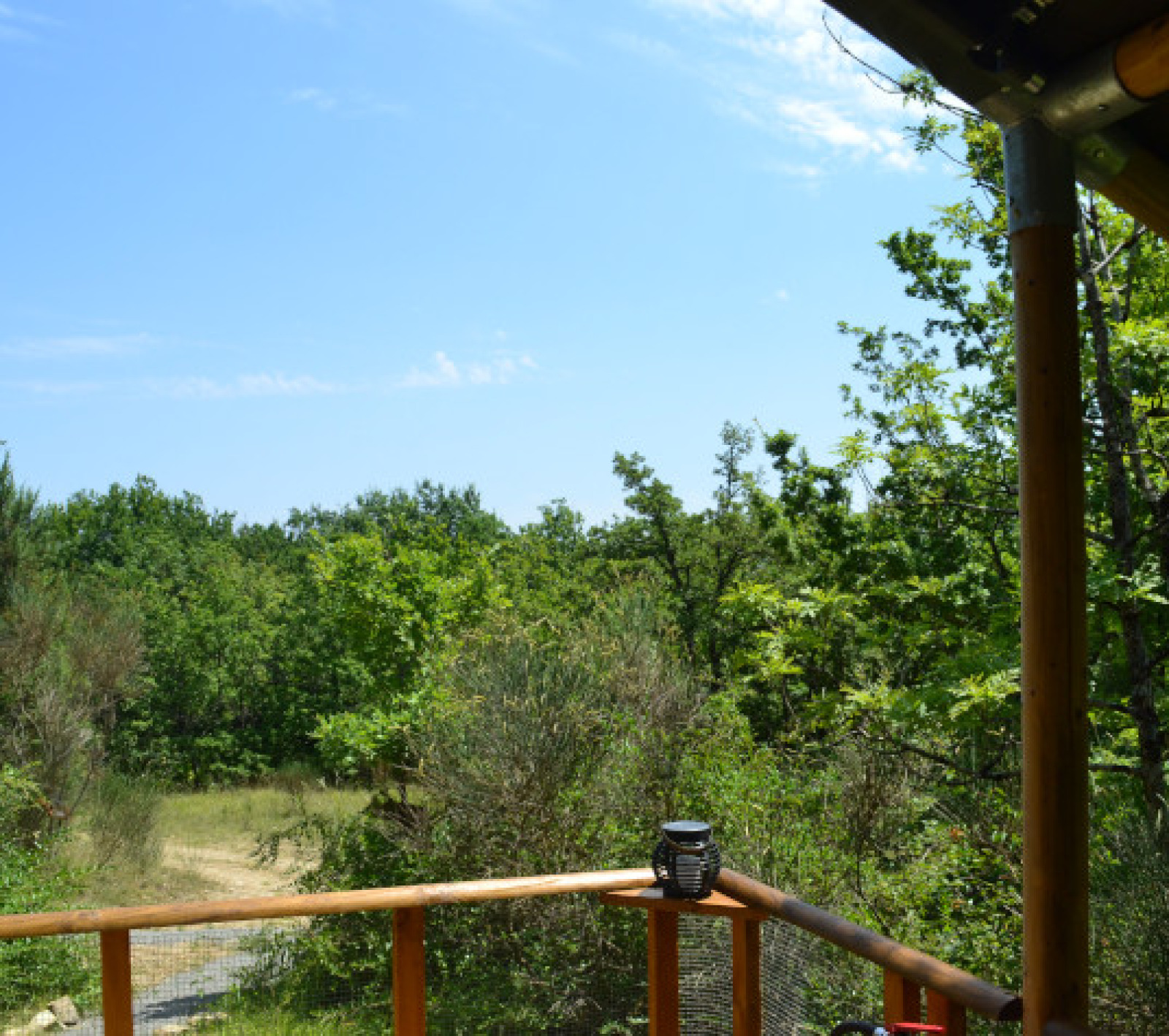 Uitzicht vanaf safaritent Lodgetent Meru bij Eco domaine Le Camp in Frankrijk, met veel groen en blauwe lucht.
