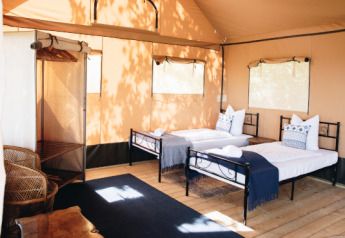 Interior de la tienda Lodgetent Samburu en Eco domaine Le Camp, Francia, con dos camas individuales.