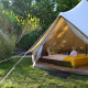 Safari-teltet Lodgetent Samburu på Eco domaine Le Camp i Frankrig med komfortabel seng og gul plaid.