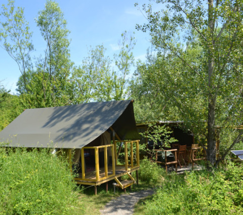 Tienda safari Lodgetent Mont Kenya en Eco domaine Le Camp, Francia, rodeada de vegetación y árboles.