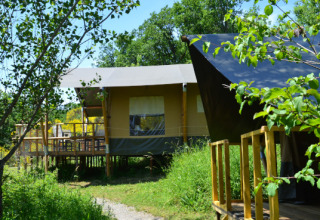 Safaritent Lodgetent Mont Kenya bij Eco domaine Le Camp in Frankrijk, temidden van het groen en de bomen.