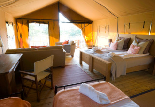 Vista interior de la tienda de safari Lodgetent Mont Kenya en Eco domaine Le Camp en Francia con cómodas camas.