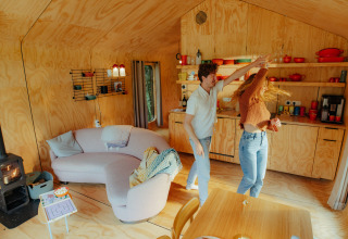 Coppia che balla felice in una cabina di legno a Les Cabanes d'Ostende, parco vacanze in Belgio.