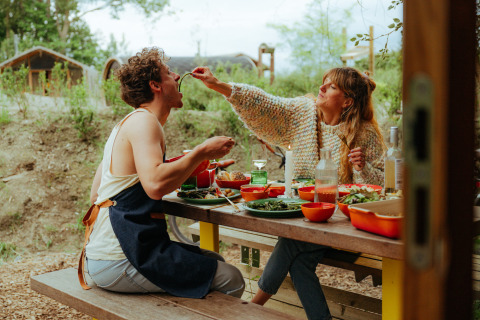 Deux personnes partagent un repas en plein air à une table de pique-nique aux Cabanes d'Ostende, Flandre occidentale.
