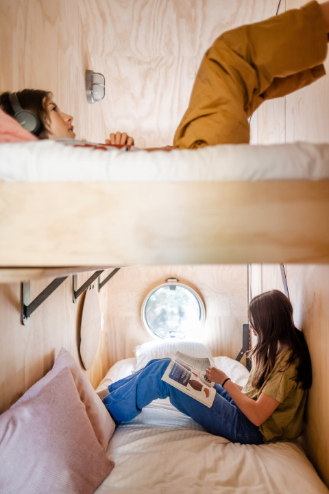 Twee personen rusten uit in een stapelbed in Les Cabanes d'Ostende in West-Vlaanderen, België.