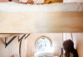 Twee personen rusten uit in een stapelbed in Les Cabanes d'Ostende in West-Vlaanderen, België.