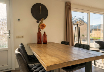 Eethoek in Velthorst-lodge bij Zilverstrand, België, met houten tafel en grote schuifdeuren.