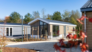 Lodge moderne Velthorst au Zilverstrand en Belgique, avec de grandes fenêtres et un cadre verdoyant.