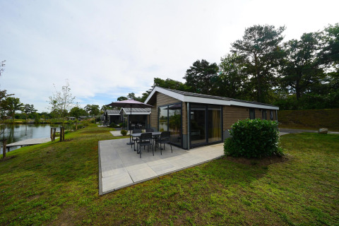 Velthorst Lodge am Zilverstrand in Belgien mit moderner Terrasse, umgeben von Natur und Wasser.