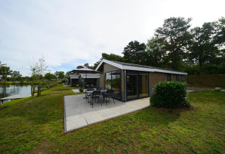 Velthorst Lodge am Zilverstrand in Belgien mit moderner Terrasse, umgeben von Natur und Wasser.