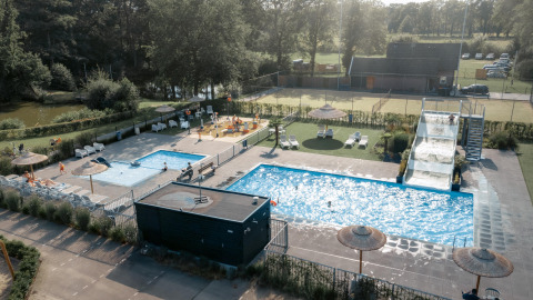 Luftaufnahme vom Camping de Italiaanse Meren in Gelderland mit Pools, Rutsche und Sonnenliegen.