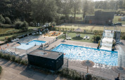 Luchtfoto van Camping de Italiaanse Meren in Gelderland met zwembaden, glijbaan en ligstoelen.