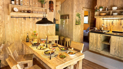 Acogedor comedor y cocina de madera en la cabaña Sunshine en Petite Suisse, Bélgica, lista para la cena.