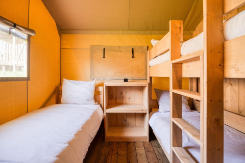 Dormitorio luminoso con literas de madera en la lodge Sunshine en Petite Suisse, Bélgica.