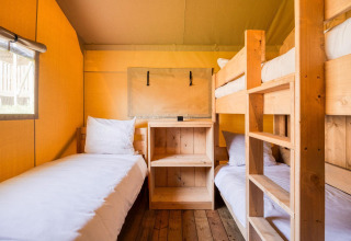 Gezellige slaapkamer met houten bedden in lodge Sunshine van Petite Suisse in België, natuurlijk licht.