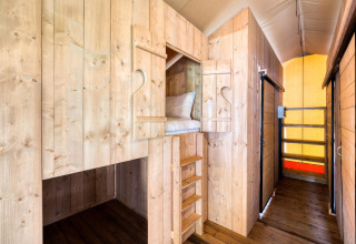 Interior de madera con literas integradas en el lodge Sunshine en Petite Suisse, Bélgica.
