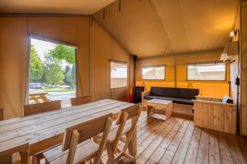 Vista interior de la cabaña Sunshine en Petite Suisse, Bélgica, con muebles de madera y ambiente acogedor.