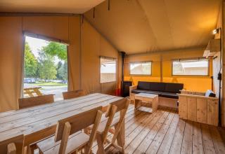 Vista interior de la cabaña Sunshine en Petite Suisse, Bélgica, con muebles de madera y ambiente acogedor.