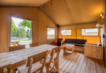 Vista interior de la cabaña Sunshine en Petite Suisse, Bélgica, con muebles de madera y ambiente acogedor.