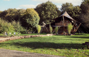 Tenda glamping Hacienda al Resort de Parel, Paesi Bassi, immersa nel verde con area relax esterna.
