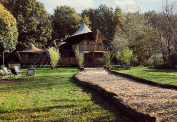 Tente glamping Hacienda au Resort de Parel aux Pays-Bas entourée de verdure et d'arbres naturels.
