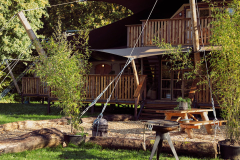 Glamping-Zelt Hacienda im Resort de Parel, Niederlande, mit Holzterrasse, Picknicktisch und Grill.